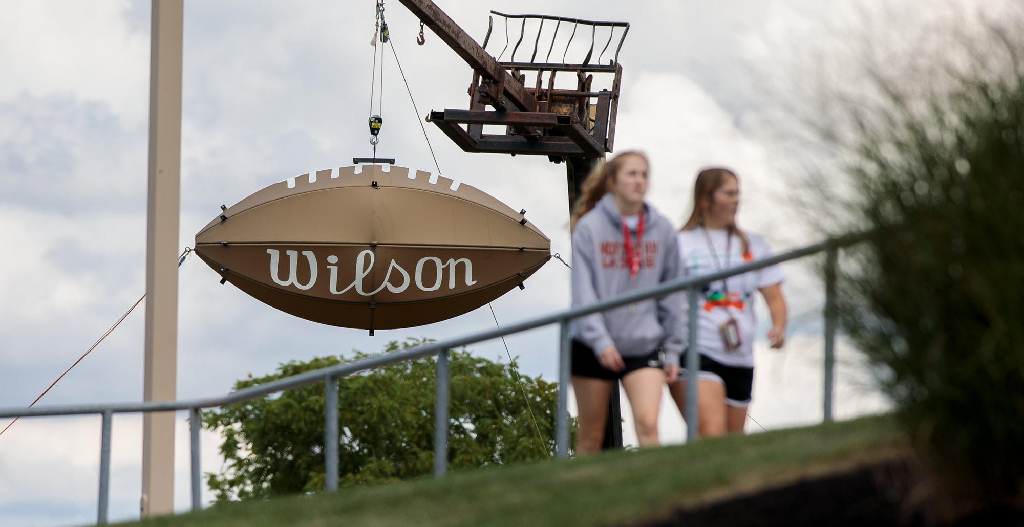 Students walk past the giant Wilson football outside of Dial-Roberson Stadium on the campus of «Ӱҵ.